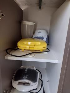 a kitchen shelf with a toaster and other appliances on it at Park veredas Rio Quente Flavia in Rio Quente