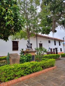 a statue in front of a white building at Casa Celeste in Zapatoca