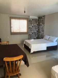 a bedroom with a bed and a table and a chair at HOTEL CITYY in Ijuí