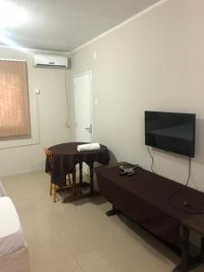 um quarto com uma mesa e uma televisão de ecrã plano em HOTEL CITYY em Ijuí