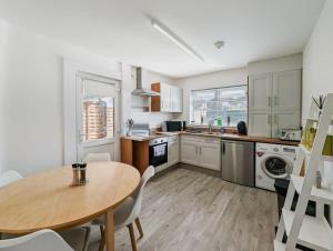 a kitchen with a wooden table and a table and chairs at Rose House - By Sigma Stays in Crewe