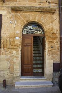 ein Backsteingebäude mit einer Holztür und einer Treppe in der Unterkunft Kerkent in Agrigento