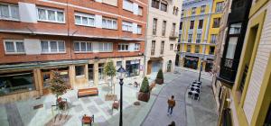 a person walking down a city street with buildings at Lugar de Alegría, Pegado a Playa, 2 Hab, 6 p, Wifi in Gijón