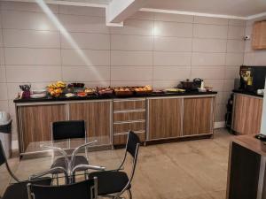 a room with a counter with a table and chairs at HOTEL CITYY in Ijuí