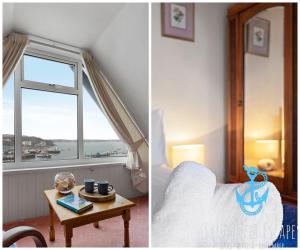 a bedroom with a bed and a window and a table at Sea Spray Villa, Brixham in Brixham