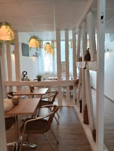 uma sala de jantar com mesas e cadeiras de madeira em La maison père camembert em Honfleur