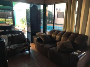 ein Wohnzimmer mit einem Ledersofa und einem Pool in der Unterkunft HOTEL CITYY in Ijuí