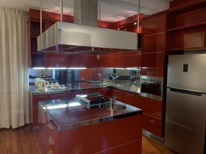 a kitchen with red cabinets and a stainless steel refrigerator at Foresteria La Corte in Castrezzato