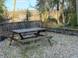 a wooden picnic table sitting on top of gravel at Bunkhouse@Glanrhyd in Pontardawe