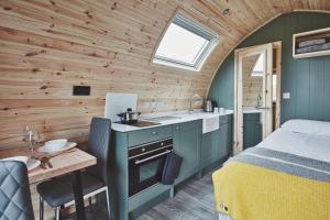 a bedroom with a bed and a sink and a kitchen at Iona Pods in Iona