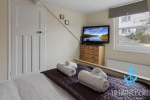 a bedroom with a bed with towels on it at Sea Spray Villa, Brixham in Brixham