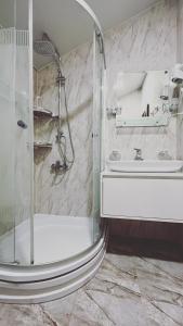 a bathroom with a shower and a sink at Keriya Hotel Shekvetili Kaprovani in Shekhvetili