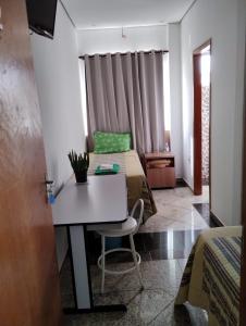 ポソス・デ・カルダスにあるHotel Pousada Beija Florのベッド2台、テーブル、椅子が備わる客室です。