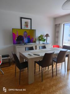 a living room with a table and chairs and a tv at LE PARADISO centre SAINT-GERVAIS in Saint-Gervais-les-Bains