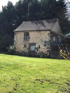 an old stone house in a field of grass at Réveil aux chants des oiseaux in Assé-le-Riboul