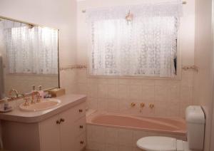 a bathroom with a sink and a tub and a toilet at Ballarat Aroma Cottage in Ballarat