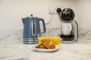 a plate of food and two glasses of orange juice at Sparkenhoe House in Hugglescote