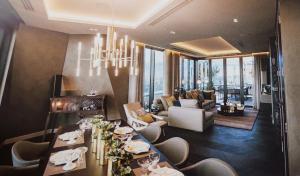 a dining room with a chandelier and a living room at Parliament House - Luxury Penthouse in London