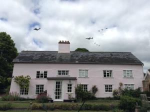 una bandada de aves volando sobre una casa blanca en The Old Dairy, Valley Farm, Middleton, en Middleton