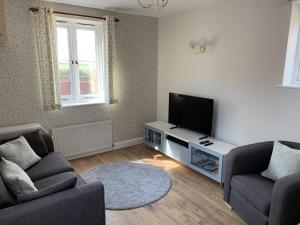 a living room with two couches and a flat screen tv at The Old Exchange in Wimborne Minster