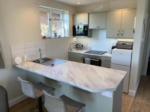 a kitchen with a counter with chairs and a sink at The Old Exchange in Wimborne Minster