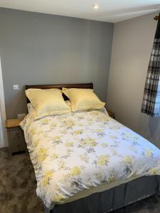 a bed with a floral comforter and two pillows at The Old Exchange in Wimborne Minster