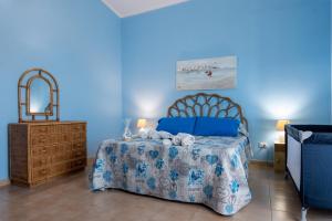 Dormitorio azul con cama y espejo en Butterfly House, en Trappeto