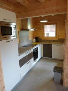 une cuisine avec une cuisinière et un micro-ondes dans l'établissement Les plagnettes, à Morzine