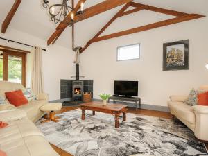 a living room with white furniture and a fireplace at Mill House in Lostwithiel
