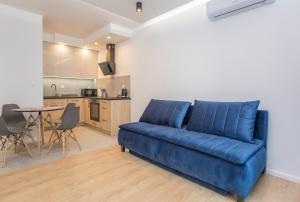 比亚韦斯托克Urban Jungle apartament Alice的客厅里的一张蓝色沙发和一张桌子