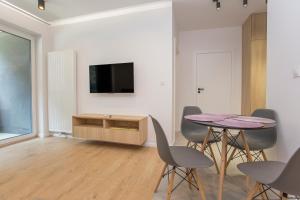 比亚韦斯托克Urban Jungle apartament Alice的配有桌椅和电视的客厅