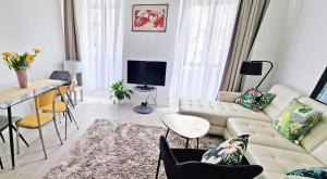 un soggiorno con divano e tavolo di Casa Bianca - 2 Bedroom Design Apartment a Trieste