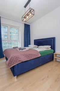 sypialnia z dużym niebieskim łóżkiem w pokoju w obiekcie Urban Jungle apartament Alice w mieście Białystok