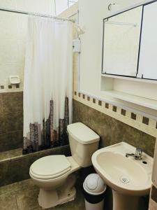 a bathroom with a toilet and a sink at Hermoso Apartamento en el Centro de Trujillo in Trujillo