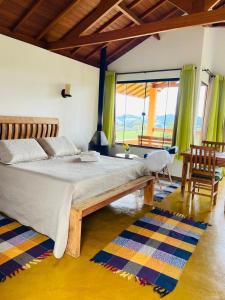 ein Schlafzimmer mit einem großen Bett und einem großen Fenster in der Unterkunft Chalés Terras Altas in Gonçalves