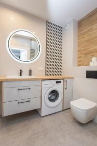 W łazience znajduje się pralka i lustro. w obiekcie Urban Jungle apartament Alice w mieście Białystok