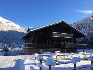 une cabane en rondins dans la neige avec une clôture dans l'établissement Les plagnettes, à Morzine 8 autres photos