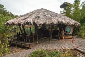 una cabaña con una mujer parada frente a ella en El Vijo Surf, en Nuquí