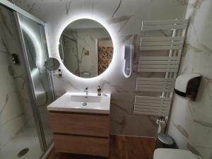 a bathroom with a sink and a shower and a mirror at Logis Hôtel Restaurant L'Odyssée Champêtre in Le Lude