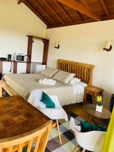 a bedroom with a bed and a table and chairs at Chalés Terras Altas in Gonçalves