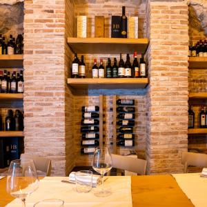 Locanda Alberti في مانديلو ديل لاريو: طاولة مع كؤوس للنبيذ في قبو للنبيذ