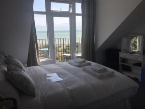 a bedroom with a bed and a large window at Seaview Sanctuary in Eastbourne