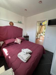 a bedroom with a purple bed with towels on it at Arabesque in Lacco Ameno