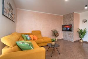ein Wohnzimmer mit einem gelben Sofa und einem Tisch in der Unterkunft Holiday house Mara with a private pool in Vodnjan