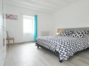 Un dormitorio con una cama en blanco y negro y una mesa en Maison Monguignon en Pécorade