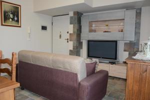 ein Wohnzimmer mit einem Sofa und einem TV in der Unterkunft XXXI MAGGIO in Catania