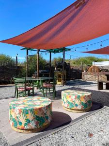 twee tafels en stoelen en een tafel met een tent bij Posada San Antonio in Valle de Guadalupe