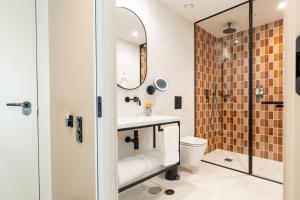 a bathroom with a sink and a toilet and a mirror at The Editory Garden Porto Hotel in Porto
