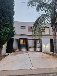a house with a black gate and a palm tree at The Green Door Cottage in Roodepoort