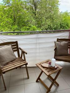 balkon z 2 krzesłami i stołem z kubkiem w obiekcie Apartman Val w mieście Zadar